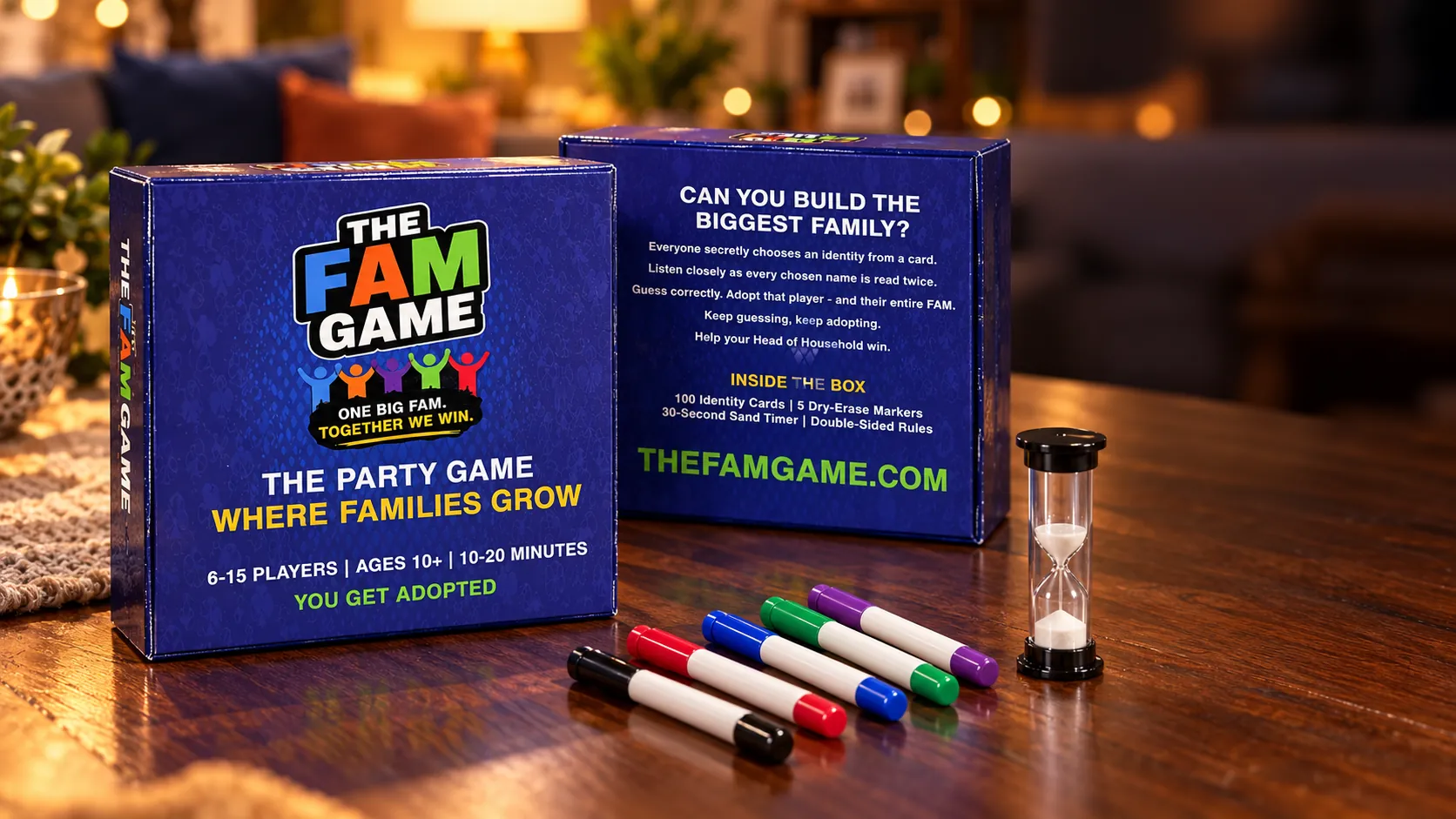 The FAM Game front and back packaging with five markers and a sand timer on a warm game-night table